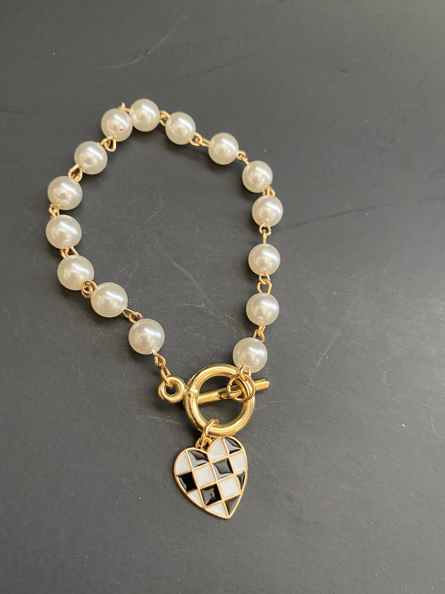 Pearl toggle bracelet with gold checkered heart charm