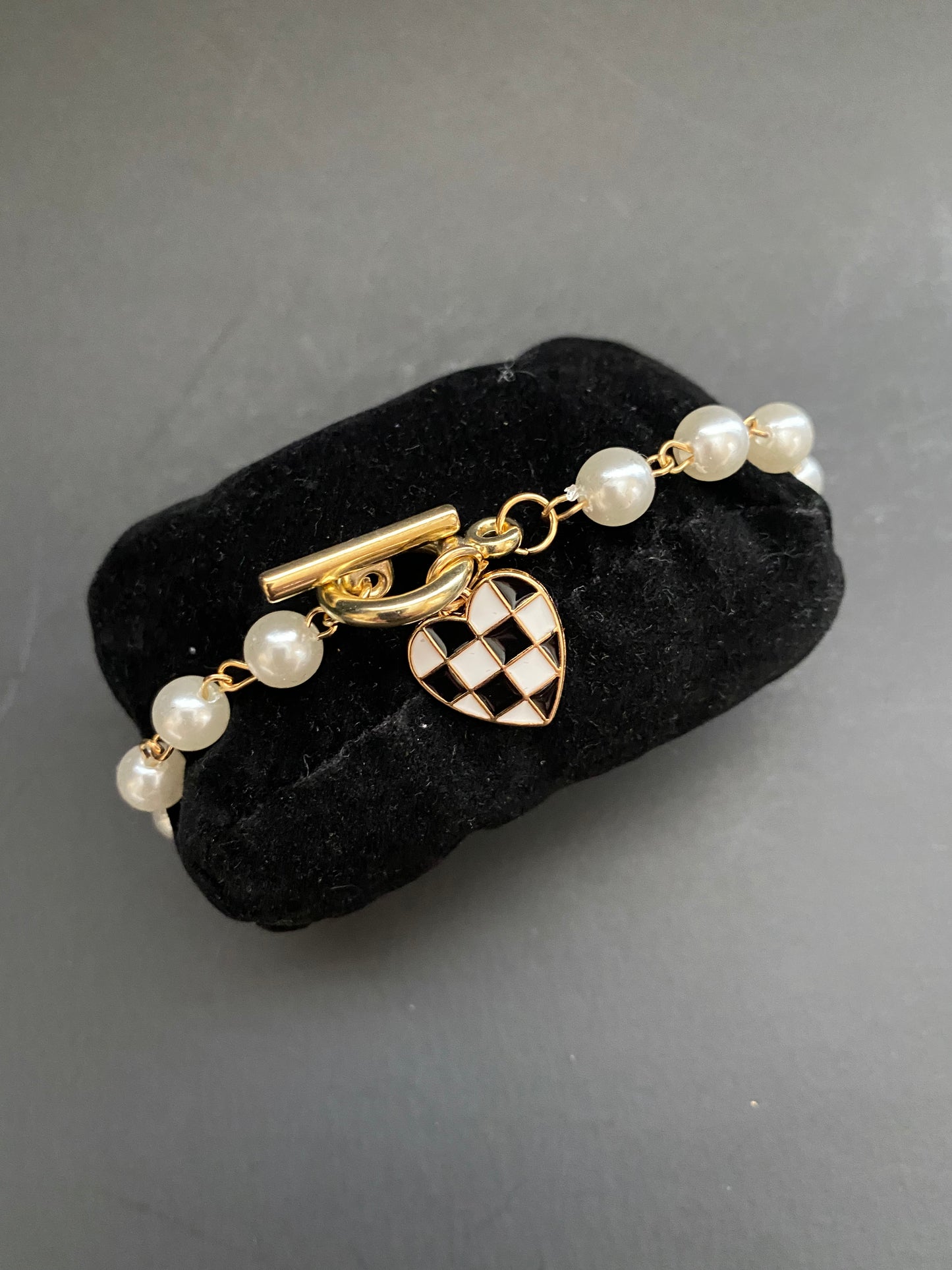 Pearl toggle bracelet with gold checkered heart charm